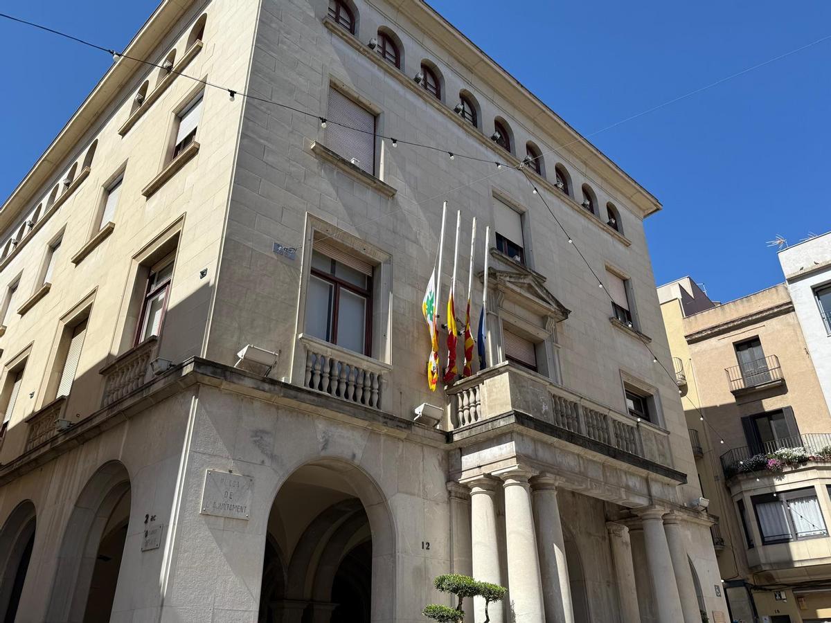 Les banderes de l'Ajuntament onejarant a mig pal.