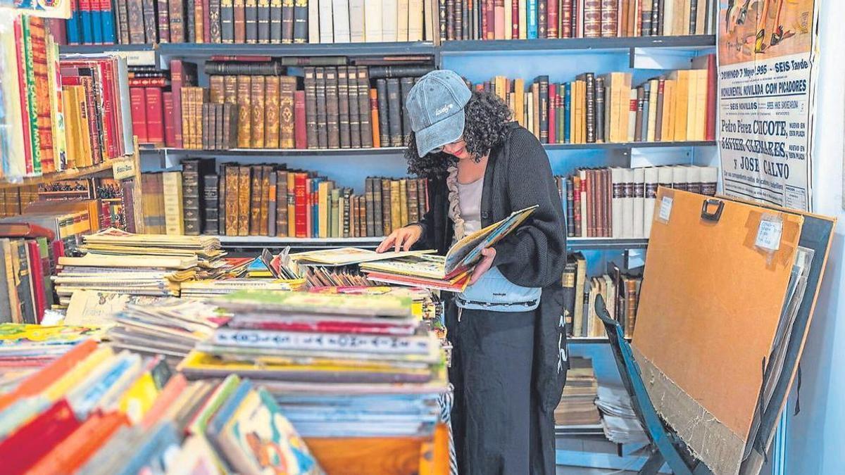 Una clienta en una parada d'una fira de llibres d'ocasió