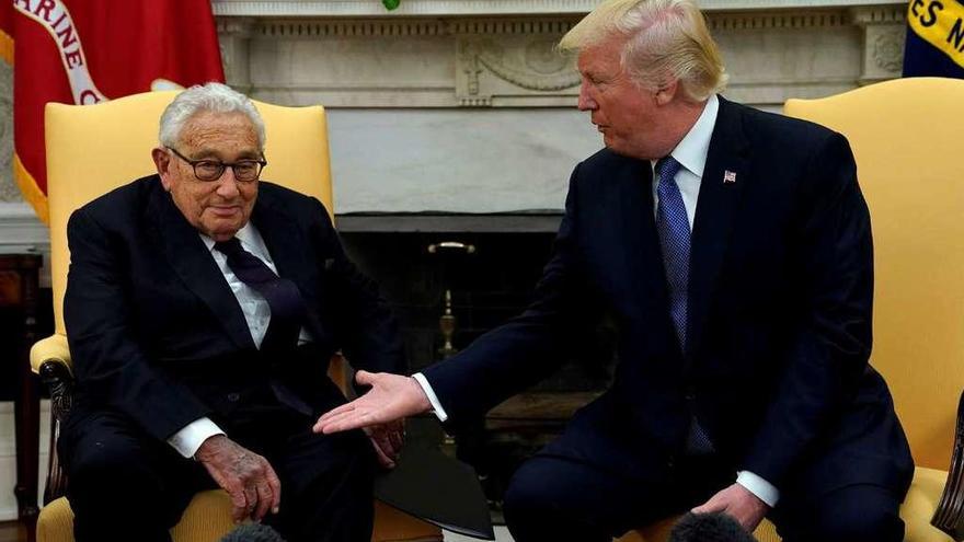 El presidente de Estados Unidos, Donald Trump, tiende su mano al exsecretario de Estado Henry Kissinger, de 94 años, ayer, en la Casa Blanca. // Reuters