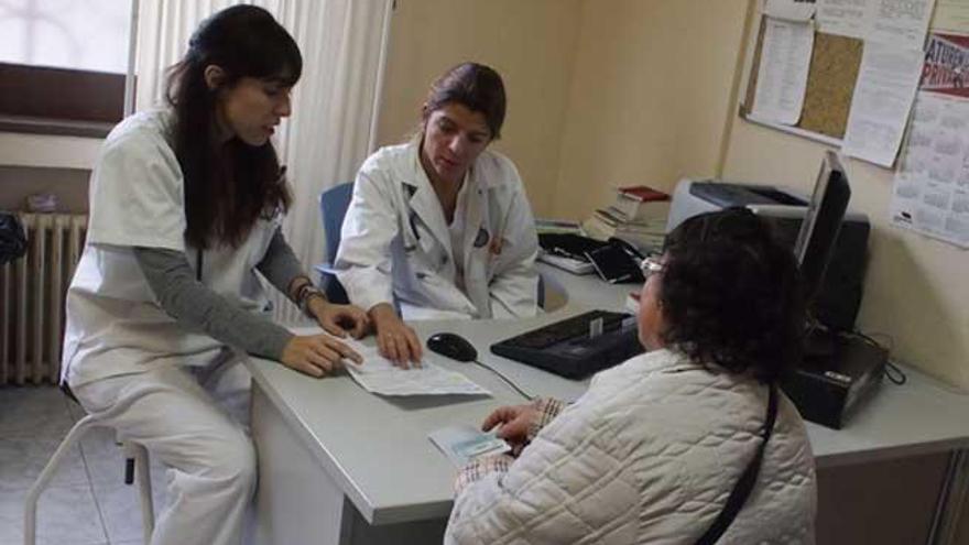 Dos profesionales sanitarias atienden a una paciente.