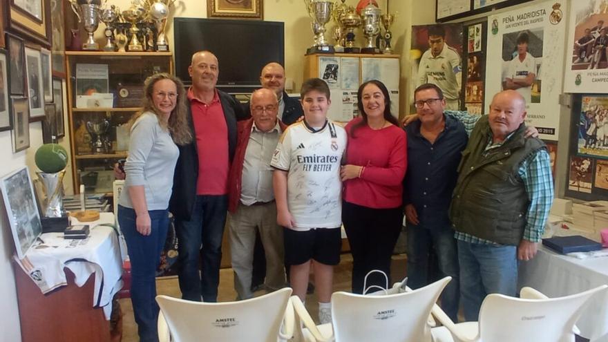 La Peña Madridista de San Vicente junto a Marcos y su familia que posa con la camiseta firmada.