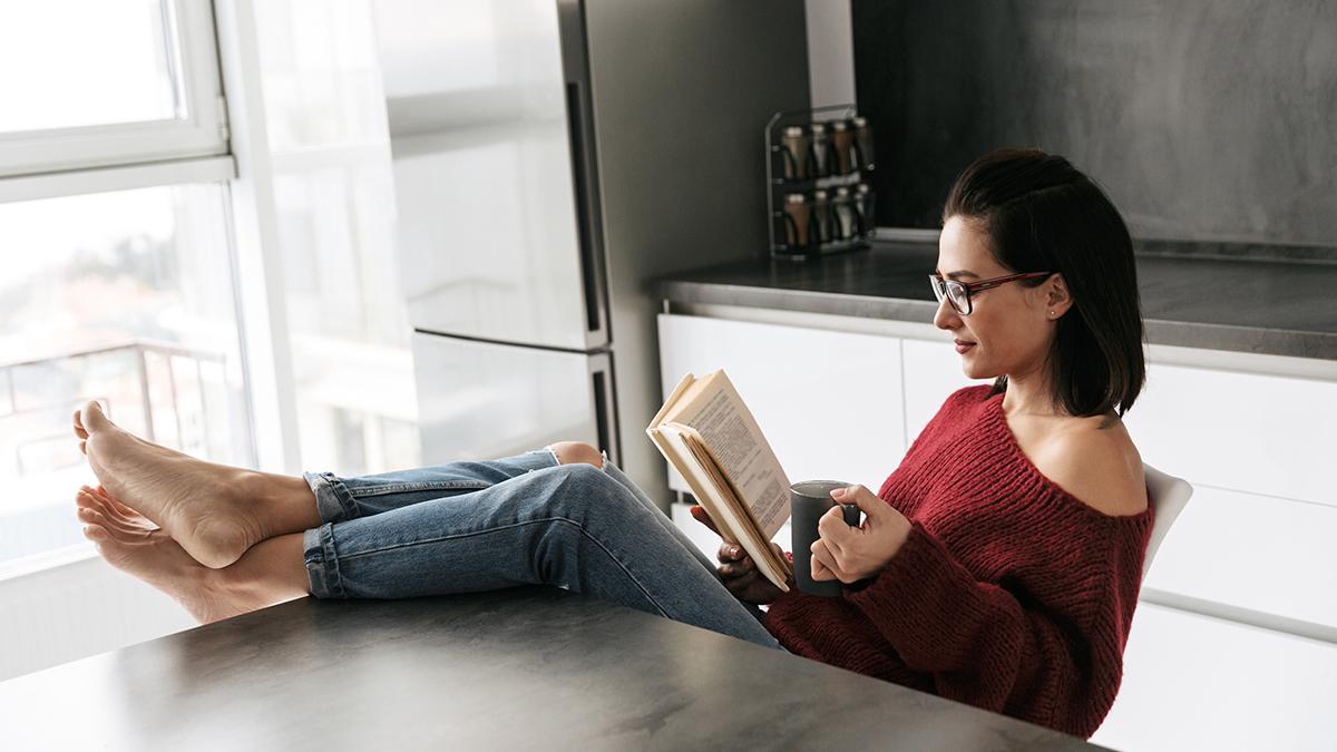 Una mujer sola en casa leyendo