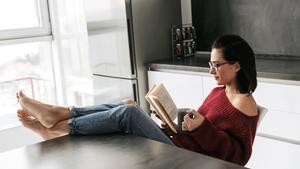 Una mujer sola en casa leyendo