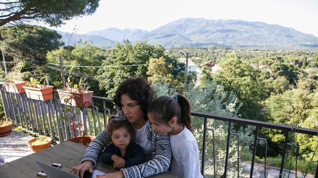 Una dona teletreballa mentre cuida les seves filles, en una imatge d’arxiu.