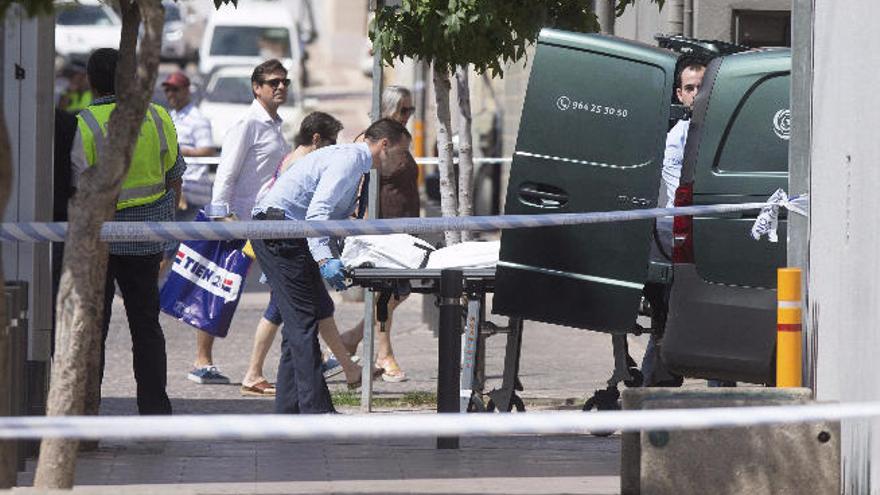 Los forenses retiran el cuerpo de la víctima de la terraza del bar.