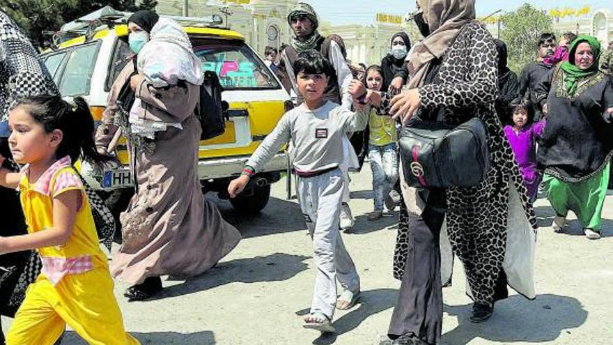 Mujeres y niños afganos huyen ayer de los talibanes en Kabul.  | REUTERS