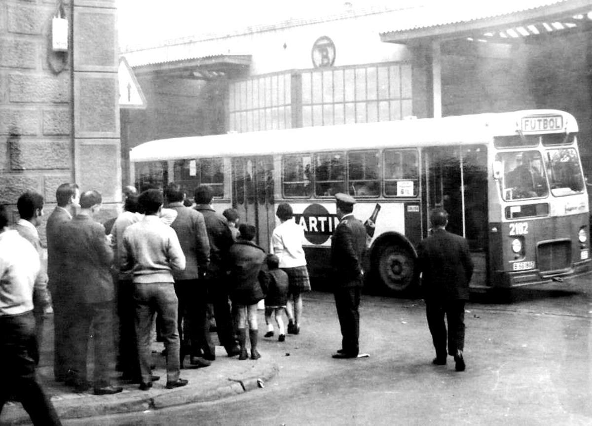 Largas colas de aficionados esperando para subir al autobús que iba a Les Corts.