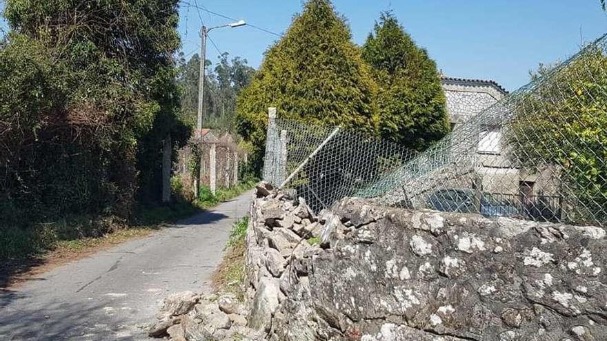 Uno de los muros que tiró el camión al quedar atrapado en la estrecha &quot;corredoira&quot; asfaltada. // GES