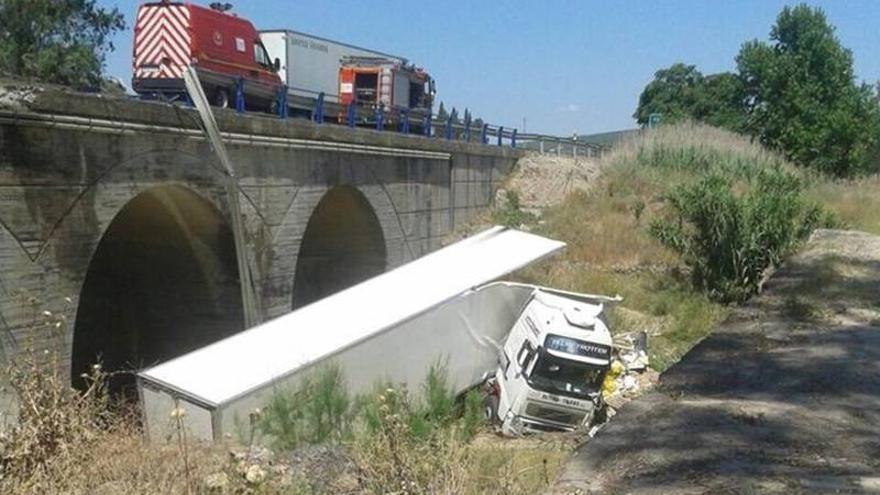 El conductor de un tráiler, herido tras caer el vehículo junto al puente romano