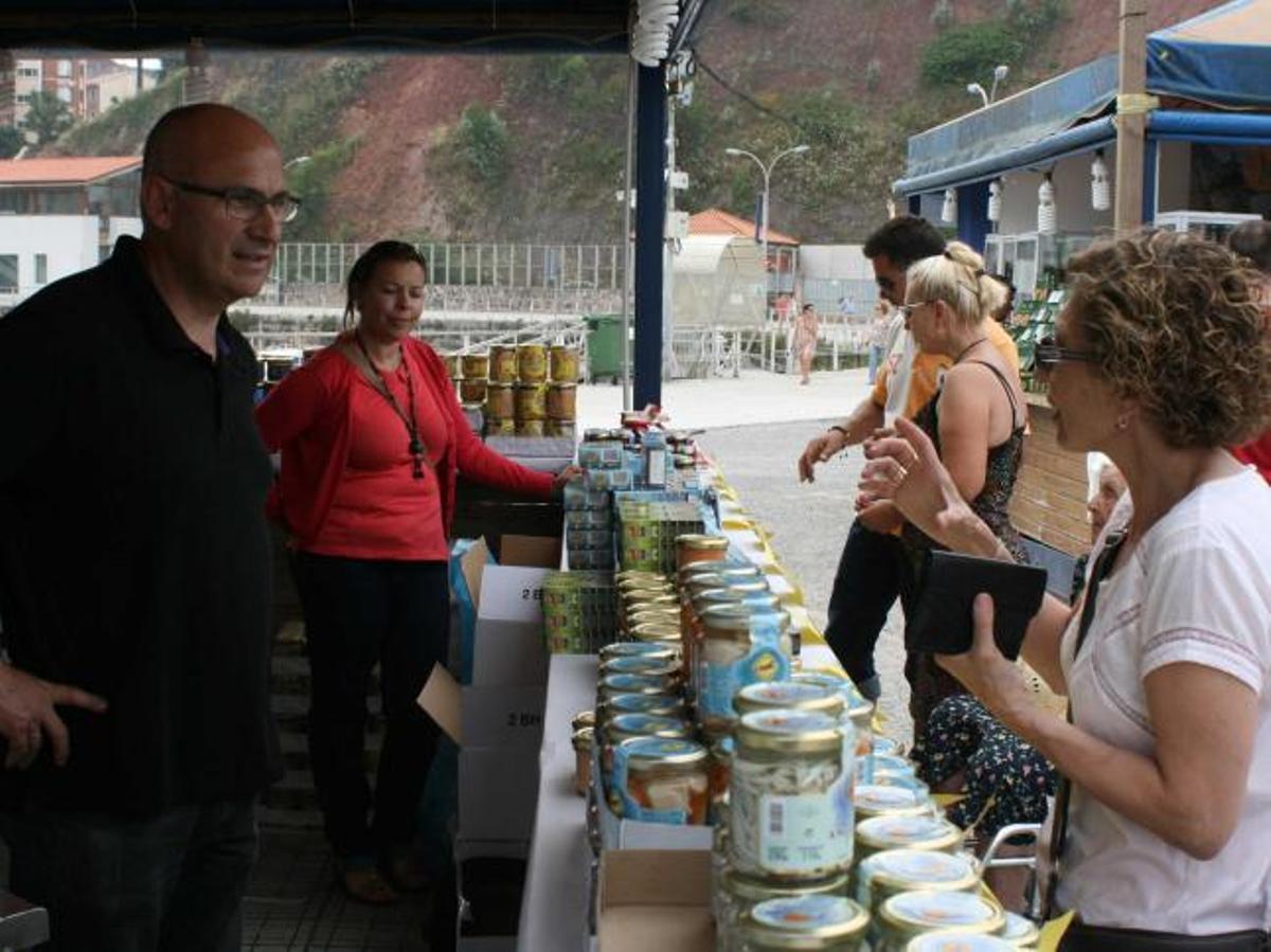 Una clienta pregunta sobre sus productos a los responsables de un puesto de la feria, ayer.