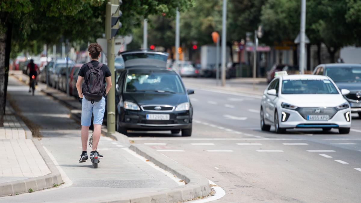 Usuario de patinete eléctrico en el centro de Castellón, sin casco.