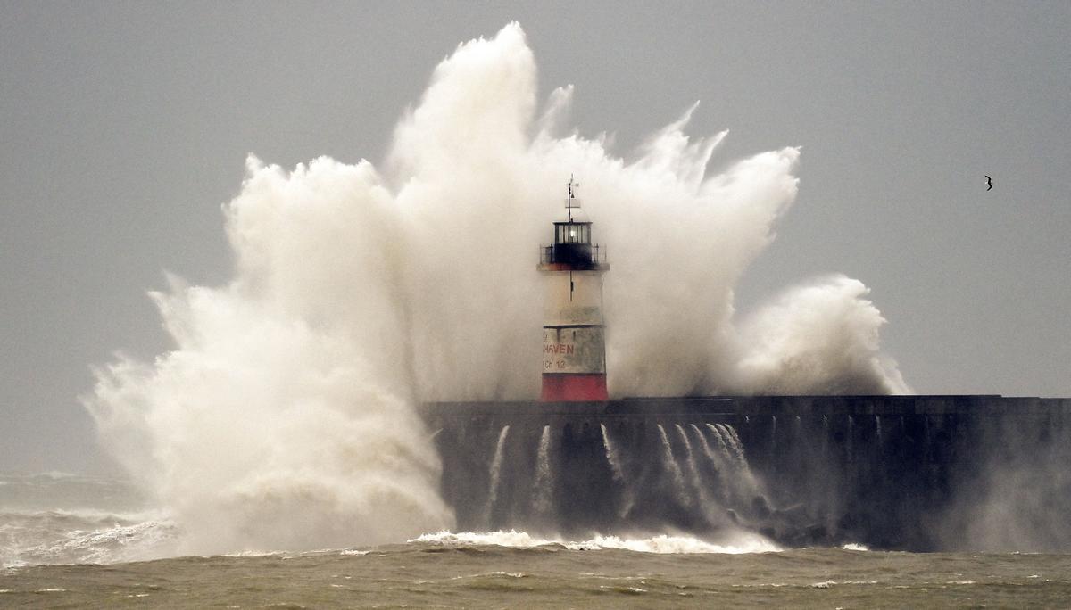 Las olas y las fuertes rachas de viento impactan sobre el faro de Newhaven, al sur de Inglaterra