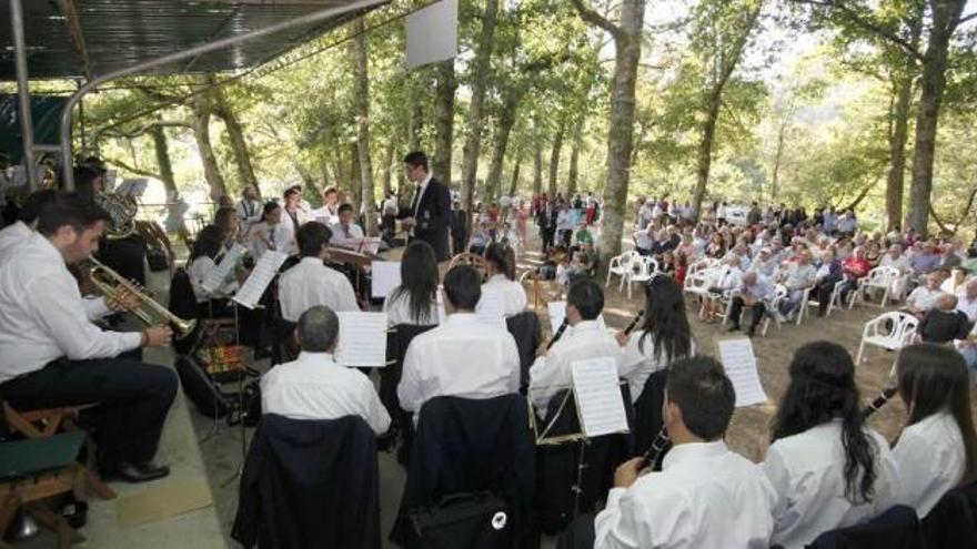 En la imagen superior, la Banda de Muimenta durante su recital en el festival. A la derecha, dos visitantes recorren la exposición de pintura. // Bernabé/Gutier