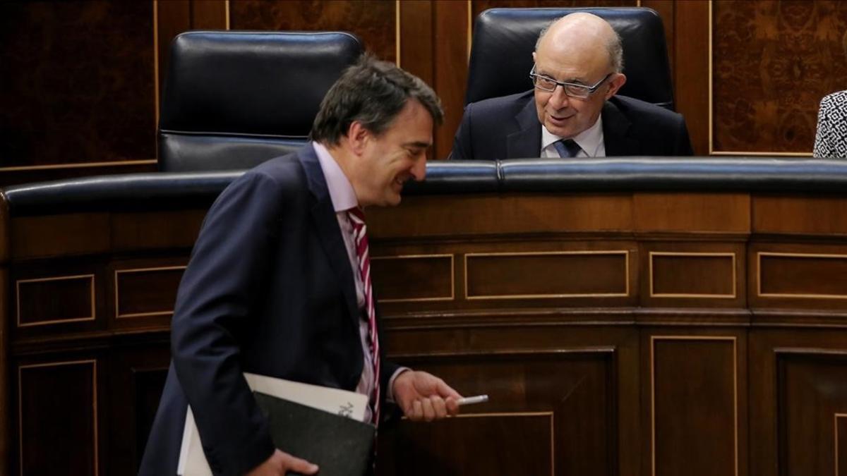 El portavoz del PNV, Aitor Esteban, bromea con el ministro de Hacienda, Cristóbal Montoro, este miércoles en el Congreso.