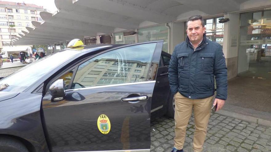 Juan Carlos Bouzo, con su taxi, ayer, en la Pola.