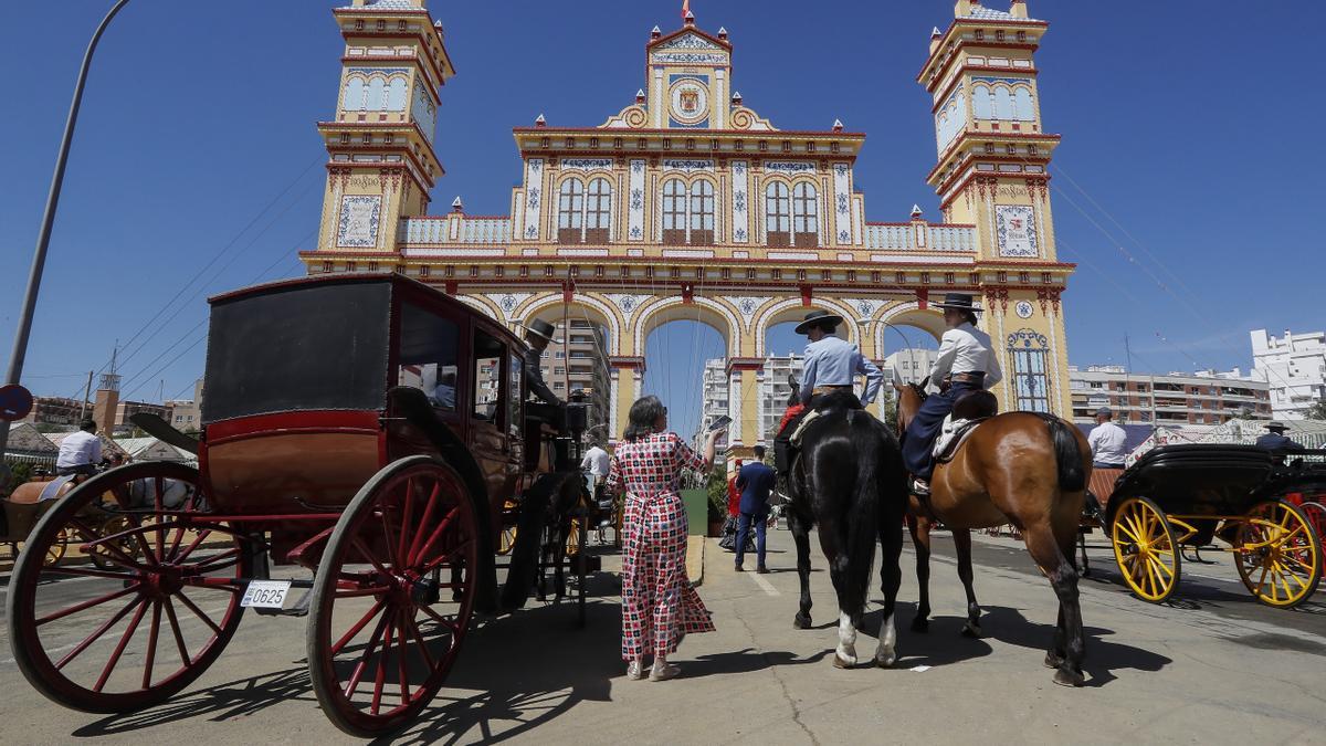 Coches de caballos frente a la portada de la Feria de Abril de Sevilla.