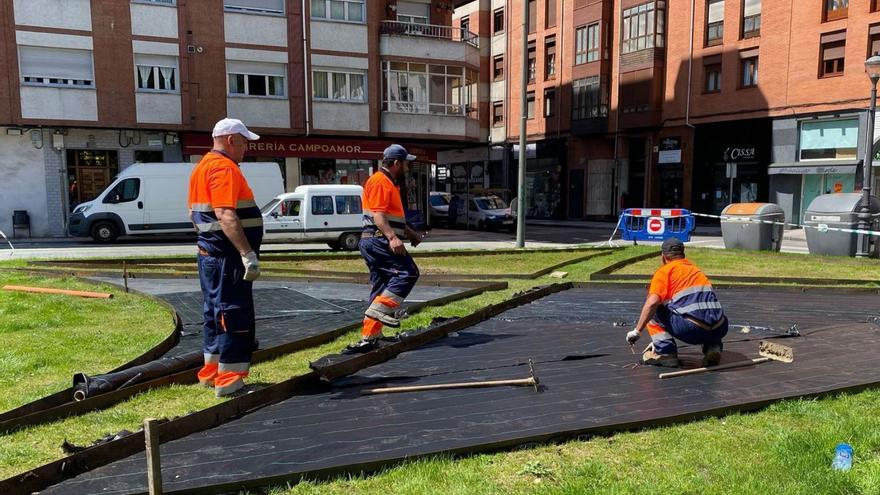 Tres operarios durante plantación de los rosales en el parque de Sama. |