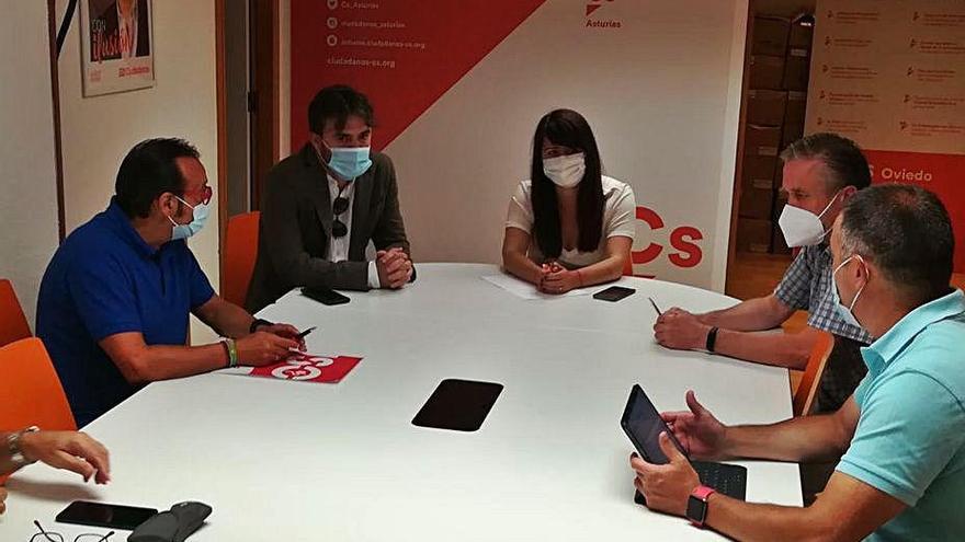 Los diputados de Ciudadanos Luis Fanjul y Laura Pérez Macho, al fondo, durante la reunión de ayer con representantes de la escuela concertada.