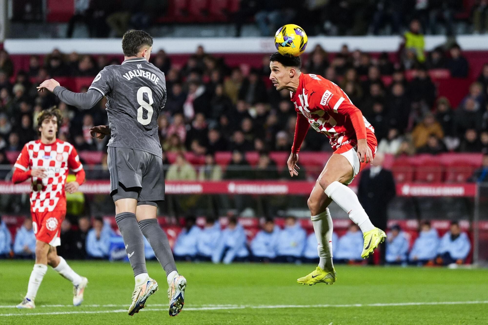 GIRONA, 07/12/2024.- El centrocampista del Real Madrid Fede Valverde (i) remata de cabeza durante el partido de la jornada 19 de LaLiga que Girona FC y Real Madrid disputan este sábado en el estadio Montilivi, en Girona. EFE/Siu Wu