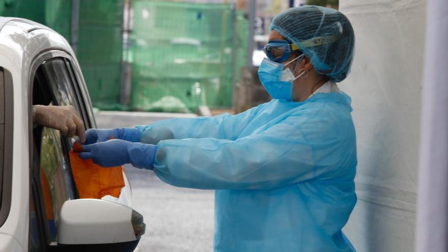 Una sanitario realiza una prueba a un paciente en un vehículo.