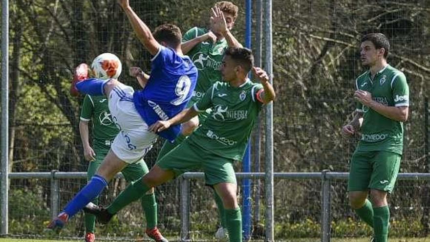 El delantero del Oviedo Cueto remata a gol ayer, frente a varios jugadores del Covadonga, en el partido en El Requexón.