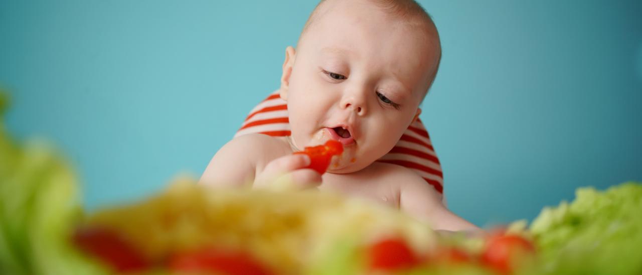 Niño comiendo vegetales.