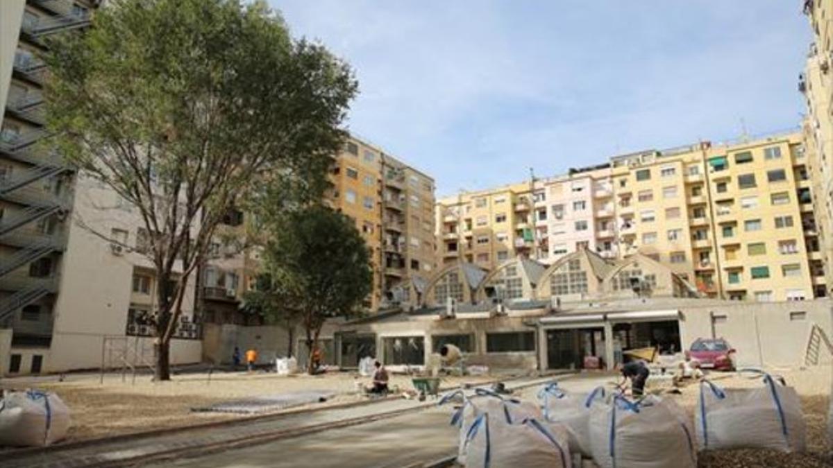 Uno de los viales y el espacio libre construido sin permiso de obras en el solar de la Gran Via calificado como parque urbano, el viernes. Al fondo, el edificio que será un comercio de coches.