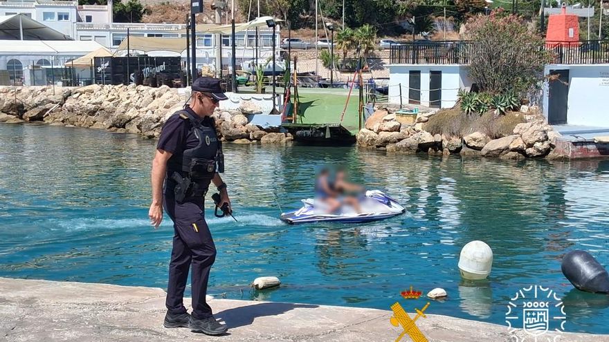 Un agente de la Policía Local de Málaga, tras detectar una infracción de una moto de agua en El Palo