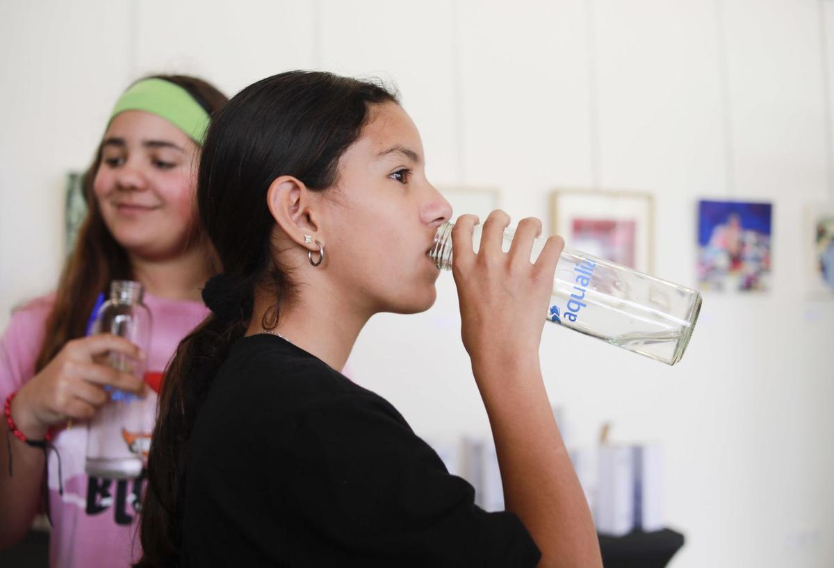 Una niña prueba una de las muestras de agua de la cata. | TONI ESCOBAR