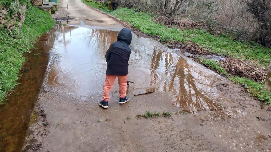 Un niño observa uno de los charcos formados en una de las vías de Villarino