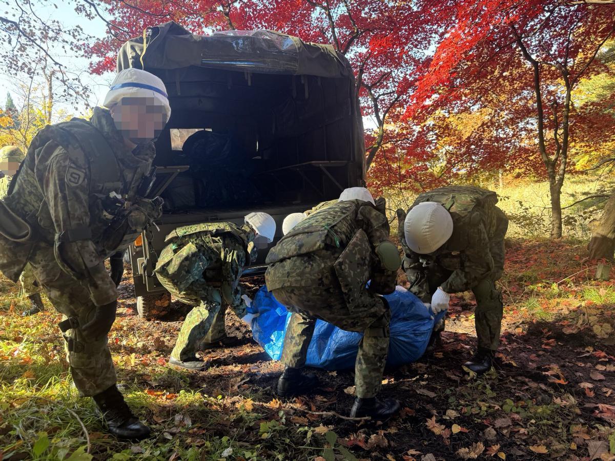 Integrantes de la Fuerza Terrestre de Autodefensa de Japón transportando un oso a un vehículo en Tokio (Japón).