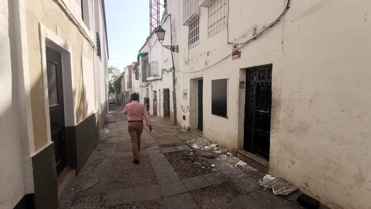 Vivienda registrada hoy en la calle San Lorenzo por la Policía Nacional, con restos de escombros en la puerta.