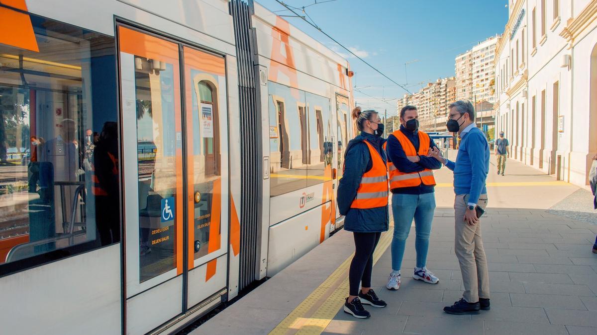 El conseller Arcadi España habla con dos técnicos del TRAM en la estación de La Marina en Alicante