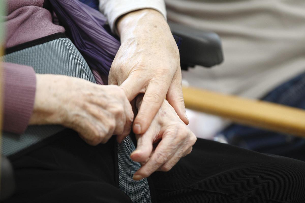 Dos mujeres dependientes se dan la mano.