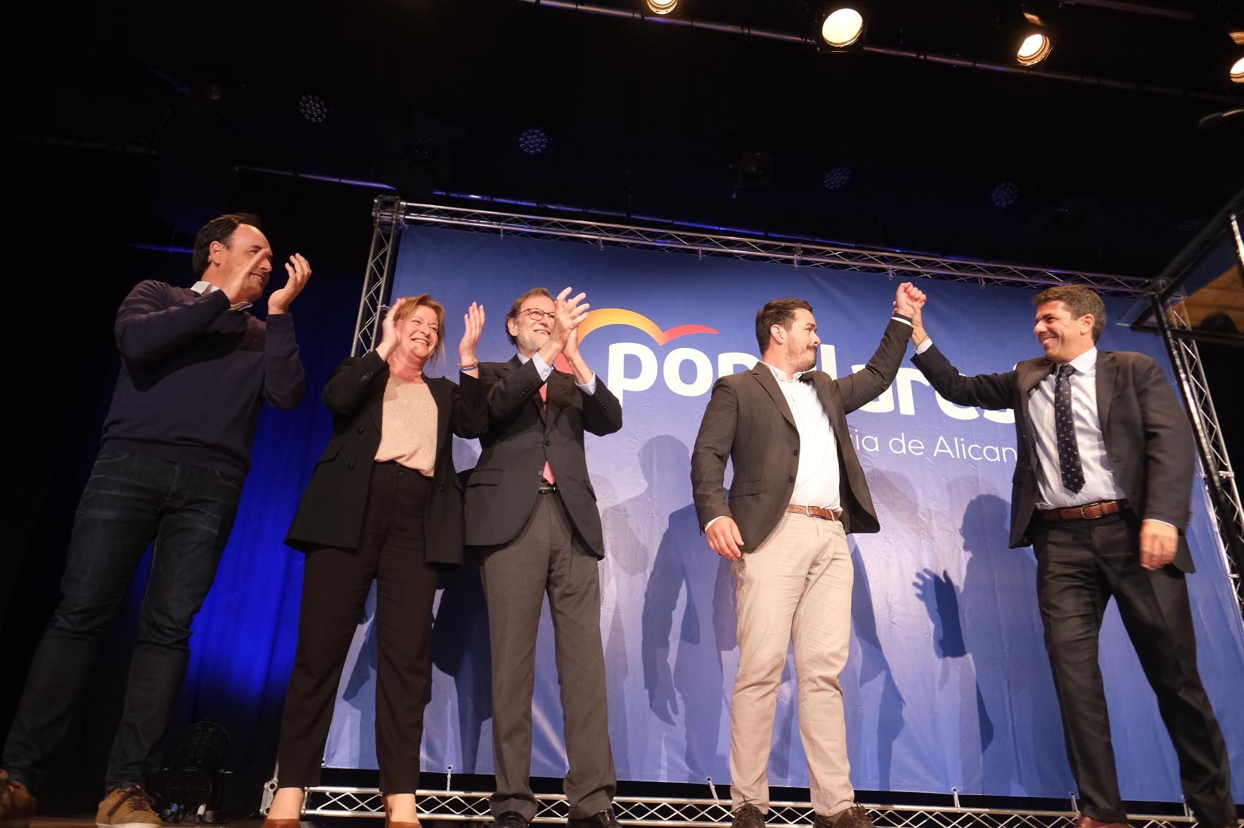 Carlos Mazón levantado la mano del candidato Miguel Ángel Salguero mientras Rajoy aplaude.