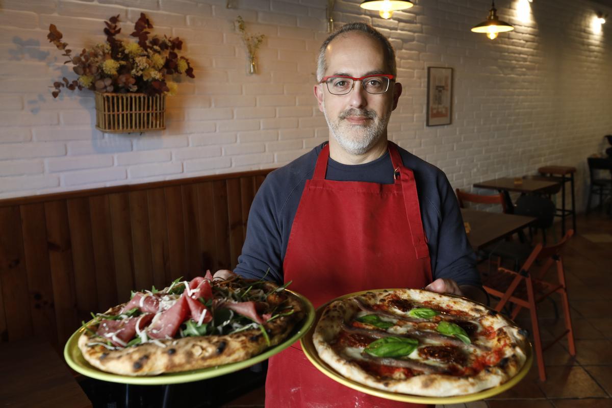 Ivano Piotti, con dos pizzas, en Oviedo.