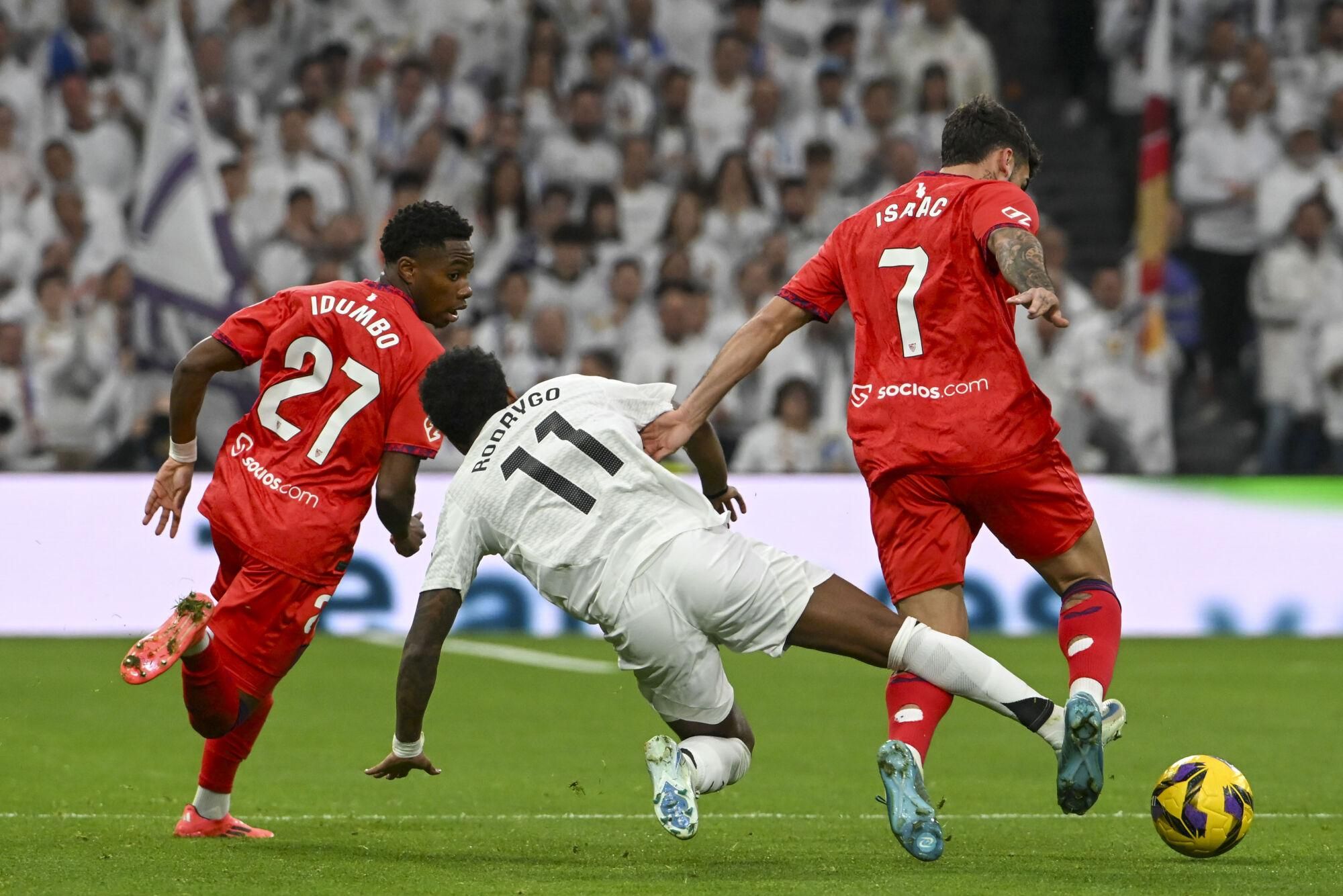 MADRID, 22/12/2024.- El delantero brasileño del Real Madrid Rodrygo Goes (c) ante dos rivales del Sevilla durante el partido de LaLiga entre el Real Madrid y el Sevilla, este domingo en el estadio Santiago Bernabéu. EFE/ Fernando Villar