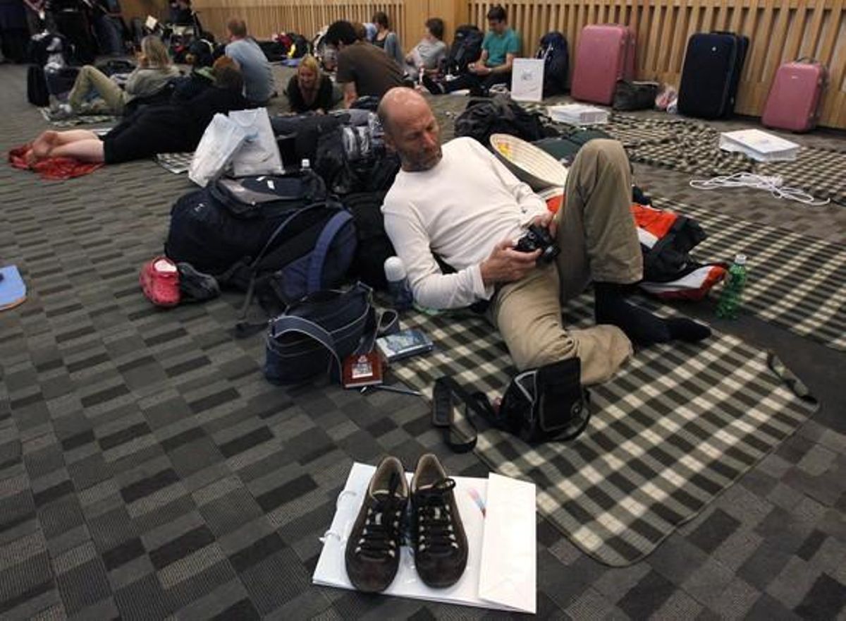 A passenger looks at his camera as he waits for his flight to Europe in a temporary waiting room at the departure terminal of Inchon International Airport