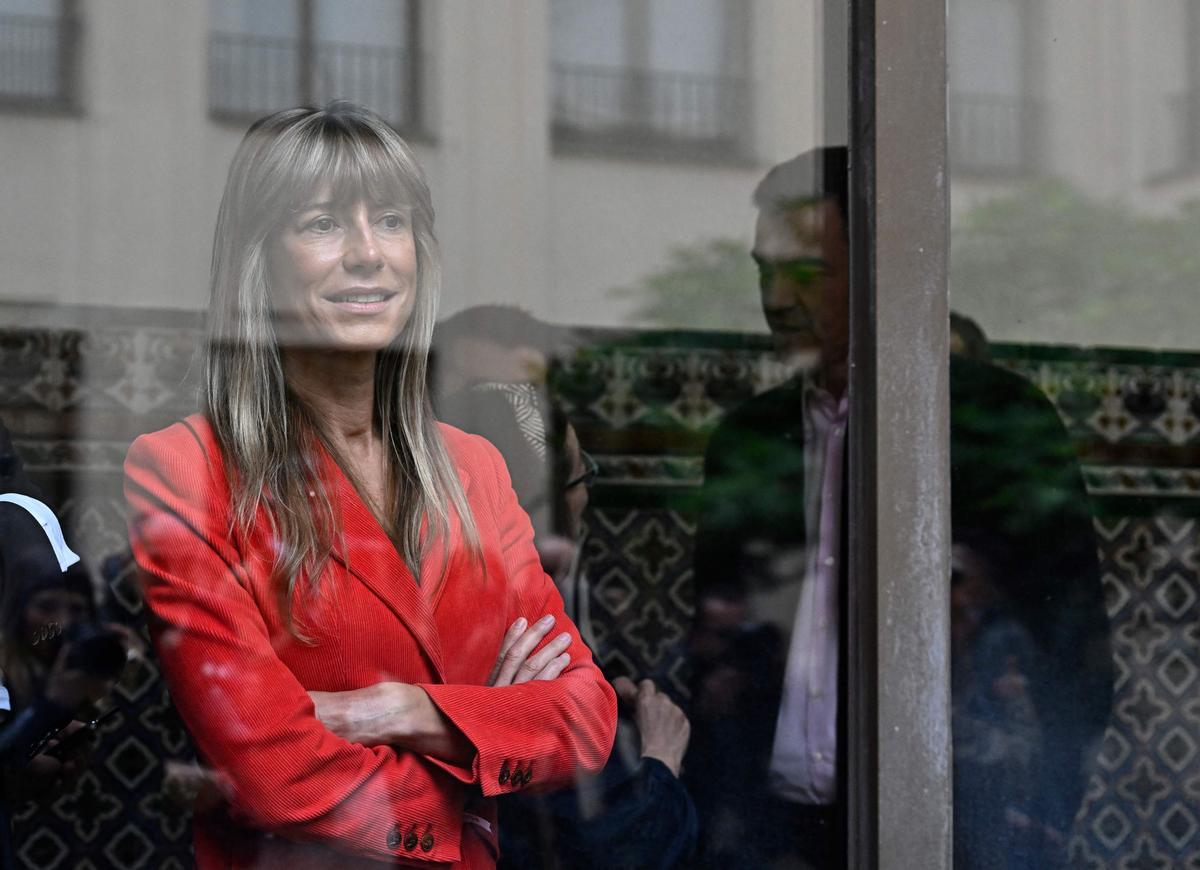 Begoña Gómez, esposa de Pedro Sánchez (a la derecha, en la imagen), tras una ventana, en el colegio Nuestra Señora del Buen Consejo, donde ella y el presidente del Gobierno han votado este domingo.