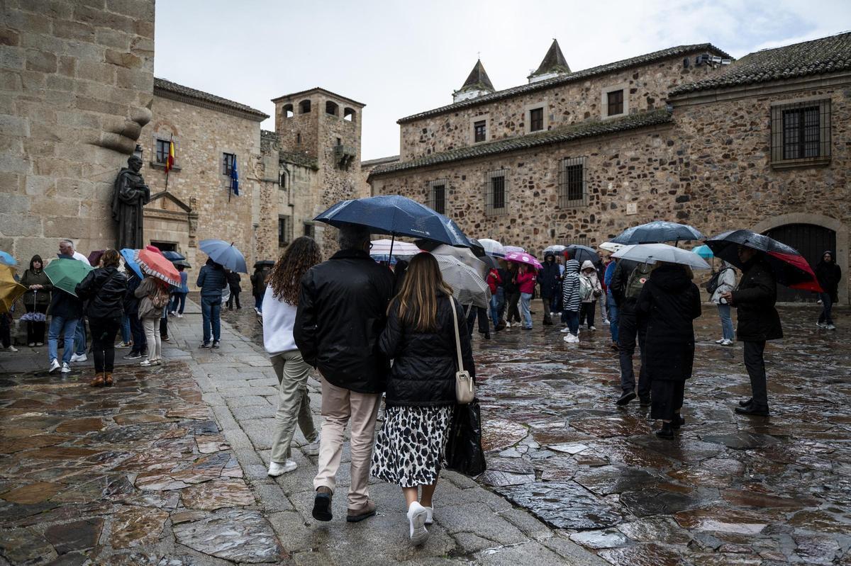 Turistas bajo la lluvia en la plaza de Santa María.