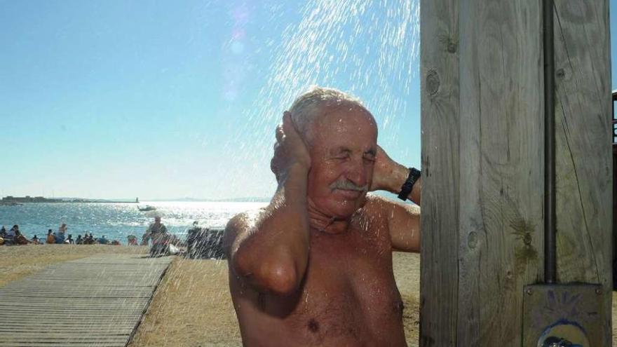 Un bañista utiliza una de las duchas de la playa Concha-Compostela, ayer. // Iñaki Abella