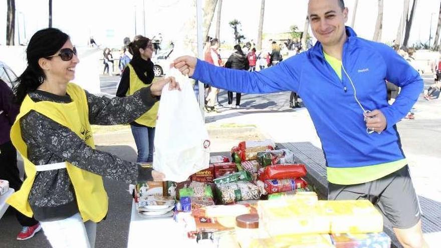 Un atleta entrega una bolsa de alimentos en la edición de 2015. // J. Lores