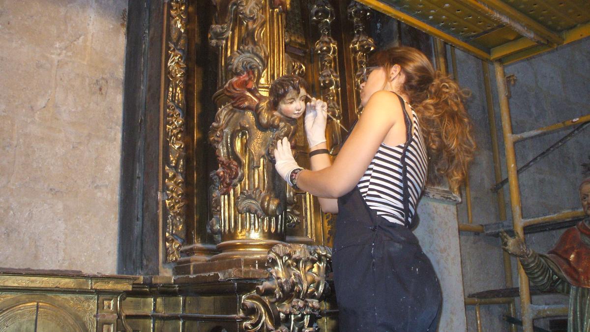 Una alumna del centro madrileño restaura un retablo en una campaña anterior