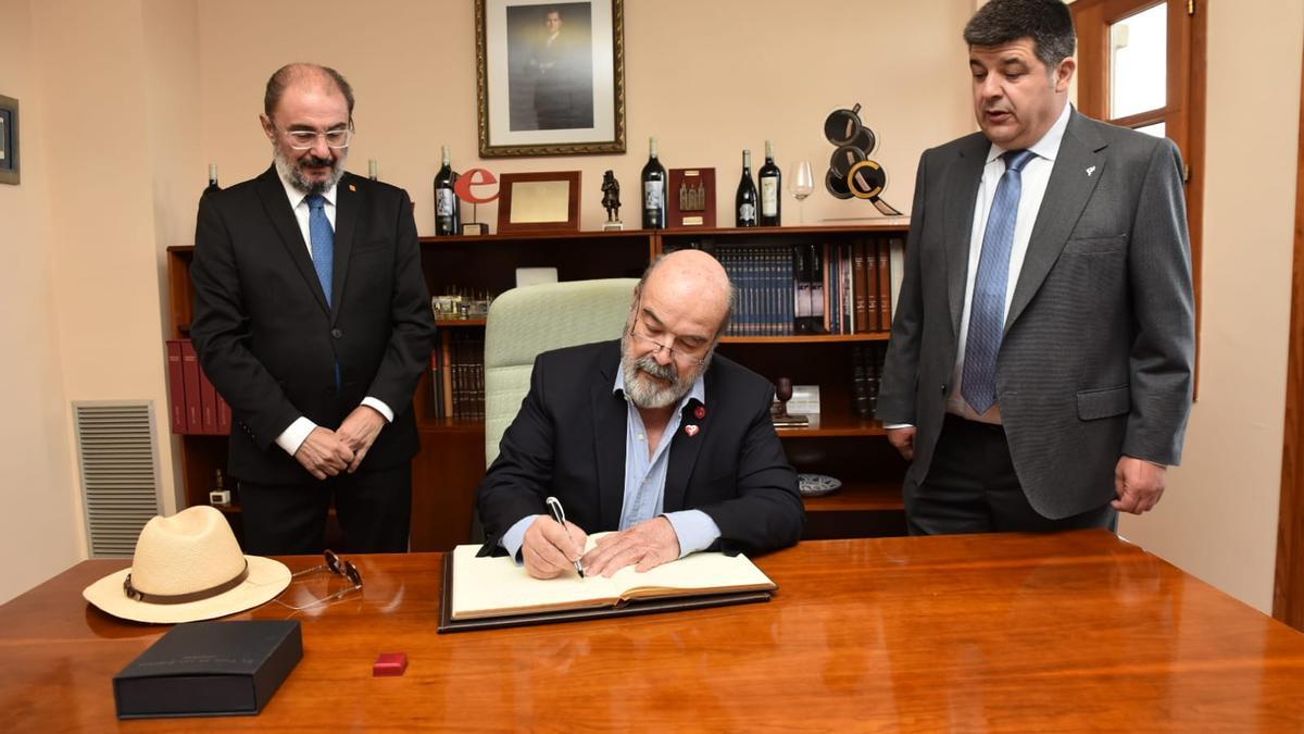 Javier Lambán, Antonio Resines y Antonio Ubide, en el momento en el que el actor ha firmado en el Libro de Oro de la DOP.