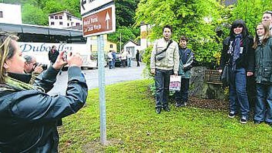 Una de las familias de Lecousse, localidad hermanada con Morcín, posa para una foto junto a un monumento en Santa Eulalia. / fernando geijo