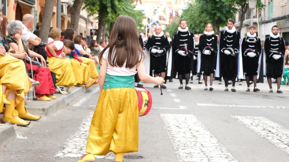 Una pequeña mora tocando el tambor al paso de una escuadra de Estudiantes en la Procesión.