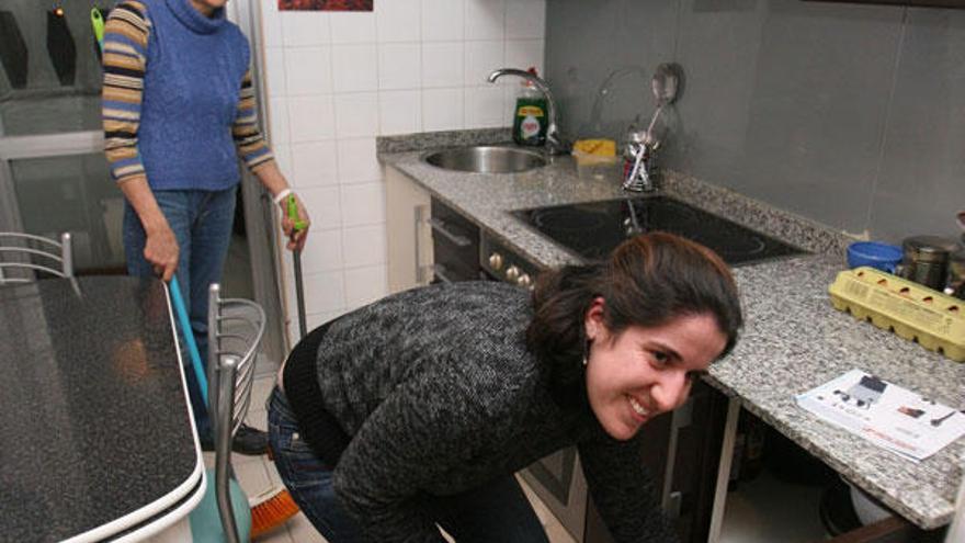 María del Carmen Alonso (al fondo, de pie) y Romina Adega en un momento de actividad en la casa que comparten.  // J. de Arcos