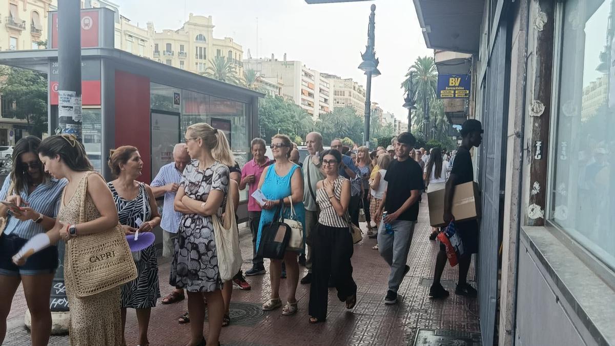 Colas para pagar la nueva tasa de basura en València.