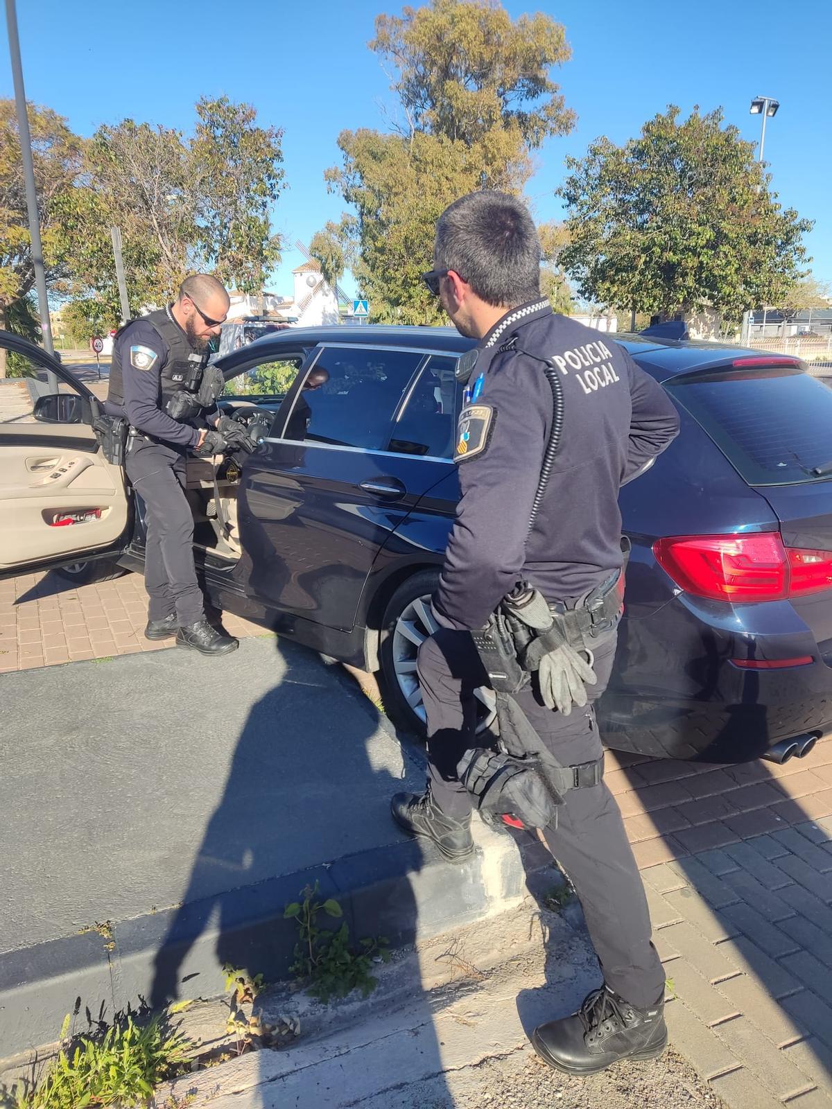 Los agentes inspeccionan el coche estrellado contra un árbol