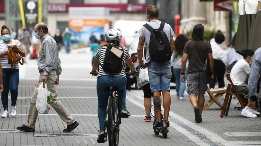 Una ciclista y el usuario de un patinete en una zona peatonal, el pasado verano.